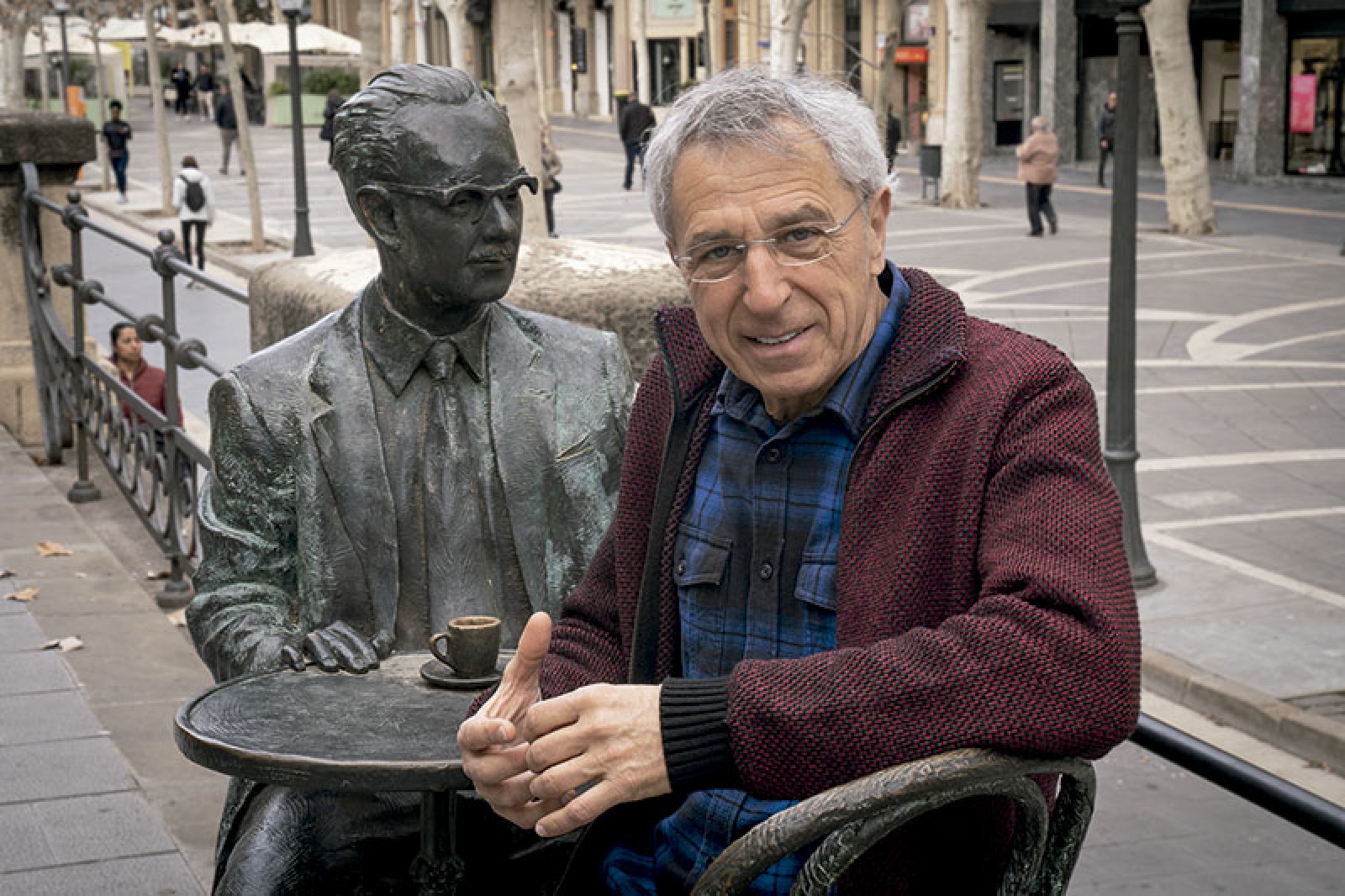 Des de l'entrada del Casino de Manresa, Joaquim Aloy seu al costat de l'escultura de Joaquim Amat-Piniella, intel·lectual manresà molt valorat a la ciutat